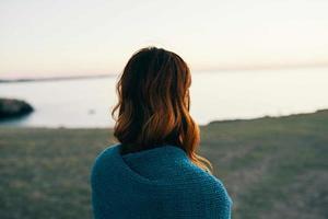 vrouw in natuur schuilplaats met een deken in de ochtend- bewondert de landschap foto