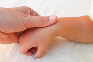 masseur aan het doen massage hand- weinig baby. foto