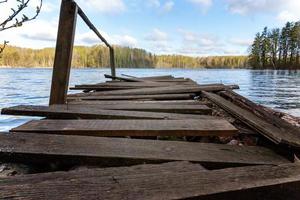 bosmeer of rivier op zomerdag en oude rustieke houten dok of pier foto