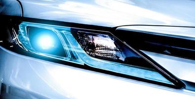 detailopname koplamp licht van een wit luxe auto. automotive industrie concept. elektrisch auto of hybride voertuig concept. auto- leasing en verzekering concept. auto leasing bedrijf. elektrisch voertuig. foto