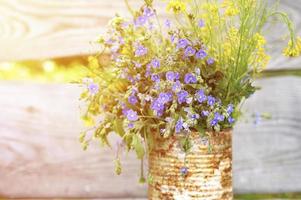 een boeket wilde bloemen van vergeet-mij-nietjes, madeliefjes en gele paardebloemen in volle bloei in een rustieke pot