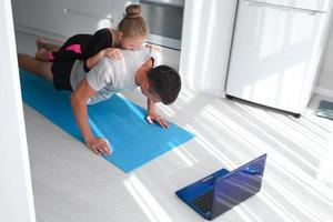 vader en dochter zijn opleiding Bij huis. training in de appartement. sport- in huis conditie. mannen is voortvarend omhoog van de verdieping foto