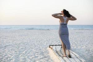 een vrouw gaat naar de zee langs een zanderig strand. zomer vakantie Aan de oceaan. foto