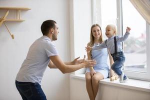 mama, vader en weinig zoon zijn spelen Bij huis. jong familie met een kind. foto