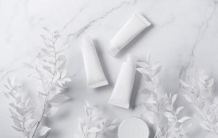 witte buizen crème op een marmeren achtergrond foto