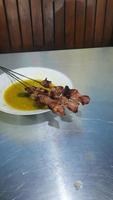klatak saté gemaakt van jong geit vlees, geserveerd met geel kerrie soep foto