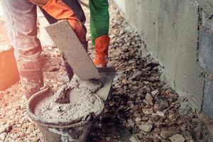 arbeider bepleistering cement Aan muur voor gebouw huis foto