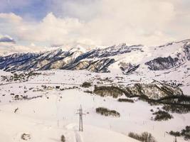hoogspanningslijn in bergen in de besneeuwde winter in Georgië foto
