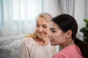 verzorger voor een ouderen vrouw wekelijks controles Bij de patiënten residentie. klaar naar geven medisch advies en praten over divers verhalen, uitwisseling elk andere gelukkig. foto