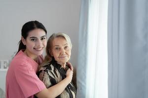 verzorger voor een ouderen vrouw wekelijks controles Bij de patiënten residentie. klaar naar geven medisch advies en praten over divers verhalen, uitwisseling elk andere gelukkig. foto