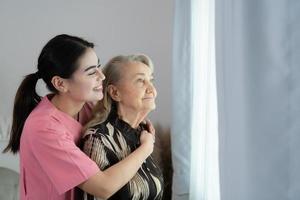 verzorger voor een ouderen vrouw wekelijks controles Bij de patiënten residentie. klaar naar geven medisch advies en praten over divers verhalen, uitwisseling elk andere gelukkig. foto