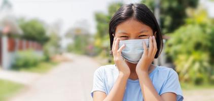 kinderen meisje vervelend gezicht masker beschermen van lucht verontreiniging en virus epidemie van covid 19 foto