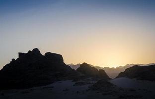 zonsondergang met rotsachtige bergsilhouetten