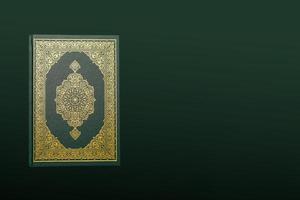 de heilig al koran met geschreven Arabisch schoonschrift betekenis van al koran en rozenkrans kralen of tasbih Aan donker groen zwart achtergrond met kopiëren ruimte. foto