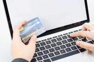 close-up van vrouwelijke handen met creditcard die online betaalt foto