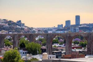 visie van de stad van queretaro Mexico aquaduct met jacaranda boom foto