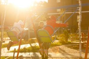 gelukkig weinig vriendinnetjes Aan schommel in park foto