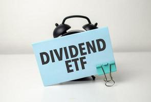 dividend etf is geschreven in een blauw sticker in de buurt een zwart alarm klok foto