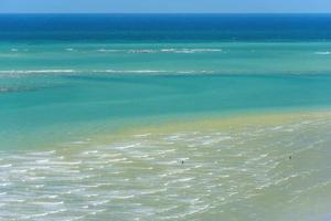 zee golven en zand van uitzicht op de bergen foto