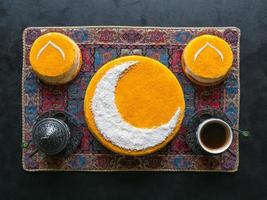 feestelijk voedsel Ramadan achtergrond. heerlijk eigengemaakt gouden taart met een halve maan maan, geserveerd met zwart koffie en datums. top visie foto