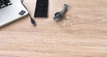horloge, mobiele telefoon en laptop op een tafel