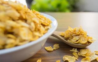 cornflakes en kom op houten tafel foto