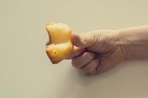 smakelijk weinig Pasen koekje Aan een kind hand- Aan een licht achtergrond foto