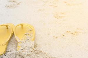 gele sandalen op het strand tijdens de zomer foto