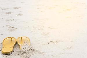 gele sandalen op het strand tijdens de zomer foto