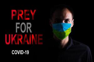 Mens met masker voor virus bescherming met tekst bidden voor de wereld corona virus covid-19 foto