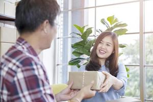 vrouw pakket geven aan een man foto