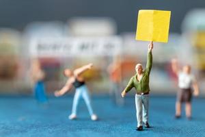 miniatuurmensen, demonstranten die borden vasthouden, hun hand opsteken voor revolutie, protesteren tegen concept foto