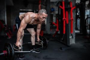 portret van Aziatisch Mens groot spier Bij de sportschool, thailand mensen, training voor mooi zo gezond lichaam gewicht opleiding, geschiktheid Bij de Sportschool begrip, grap naar buik spieren foto