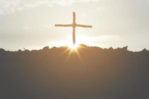 kruis kruisiging van jezus christus op een berg, silhouet met een zonsondergang achtergrond. pasen of goede vrijdag concept foto