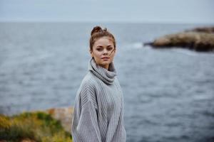 vrouw truien bewolkt zee bewonderend natuur ongewijzigd foto