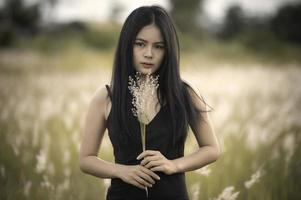 portret van mooi Aziatisch vrouw Bij gras veld- Aan zonsondergang foto