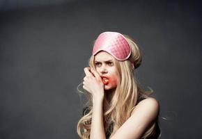 dronken blond met roze slaap masker uitstrijkjes lippenstift allemaal over- haar gezicht foto