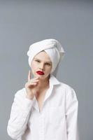 vrouw met een handdoek Aan haar hoofd in een wit overhemd foto