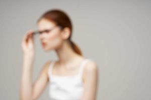 vrouw in wit t-shirt bril in de handen van astigmatisme licht achtergrond foto