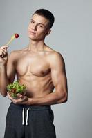 atletisch knap Mens gespierd torso bord salade Gezondheid eetpatroon foto