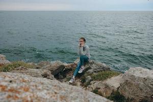 vrouw truien bewolkt zee bewonderend natuur vrouw ontspannende foto