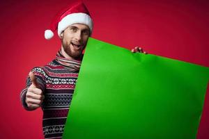 knap Mens in een Kerstmis hoed met groen mockup rood achtergrond foto