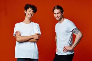 grappig twee mannen in wit t-shirts Aan een rood achtergrond vriendschap foto