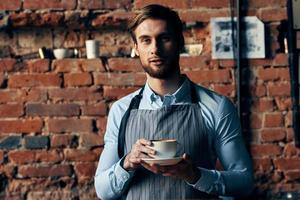 mannetje ober schort koffie kop steen muur restaurant onderhoud foto