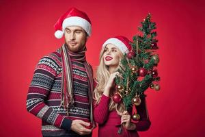 schattig Mens en vrouw nieuw jaar boom decoratie vakantie rood achtergrond foto