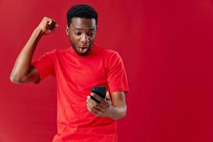 emotioneel Afrikaanse Amerikaans op zoek in de telefoon technologie communicatie rood achtergrond foto