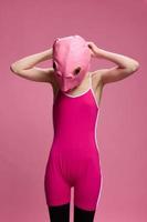 heel vreemd vrouw in een roze siliconen vis masker voor halloween, gek beeld in roze kleren foto