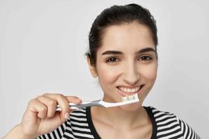 vrouw borstel uw tanden met een tandenborstel geïsoleerd achtergrond foto