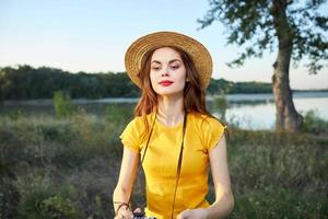 vrouw in geel t-shirt hoed rood lippen fotograaf natuur vers lucht foto