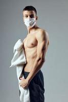 Mens met een opgewonden torso medisch masker virus bescherming Sportschool foto